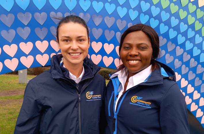 Two of Community Home First's Community Connectors standing in front of a rainbow sculpture at the Countess of Chester Hospital.